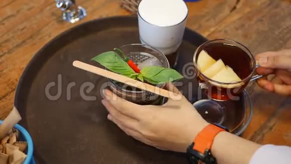 女服务员正把茶杯和咖啡放在一个圆形托盘上并为咖啡厅的顾客准备点菜视频的预览图