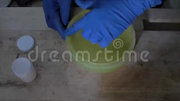 特写戴着手套的工人在浇注混凝土前润滑硅酮模具的手手工艺品4k4k视频59岁视频的预览图