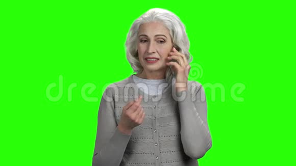 自信的高级女性在透明电话上交谈视频的预览图
