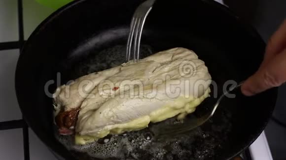 在一个加了黄油的加热煎锅里鸡角卷被炸了一个人用叉子翻卷你可以看到石油是怎样的视频的预览图