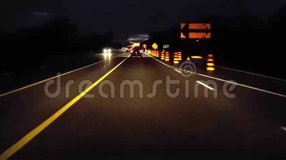 行车道在夜间用施工标志结束乡村道路司机的观点POV橙色警告路标视频的预览图