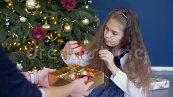 帮助装饰圣诞树的小女孩视频的预览图