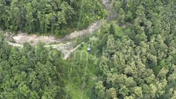 无人驾驶缆车在青山上的索道上进行空中射击视频的预览图