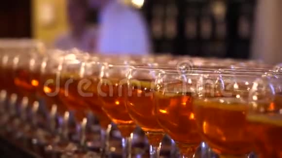 酒吧柜台上有很多酒杯橙色饮料里面有一块橙色的鸡尾酒杯视频的预览图