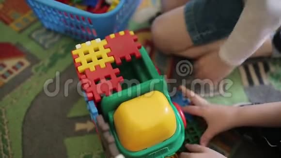 幼儿玩彩色塑料玩具汽车的游戏两个男孩收集彩色塑料制品视频的预览图