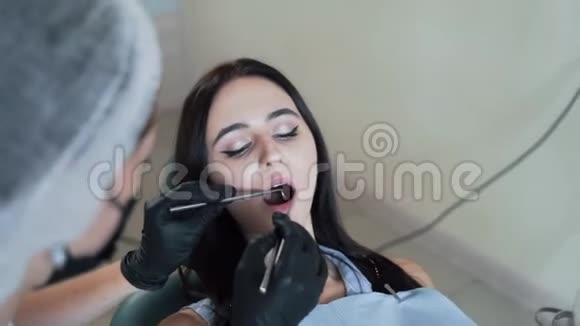 牙医用牙科工具检查病人牙齿动作缓慢牙医办公室的女人视频的预览图