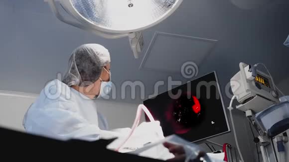 手术室里的女人看着监视器视频的预览图
