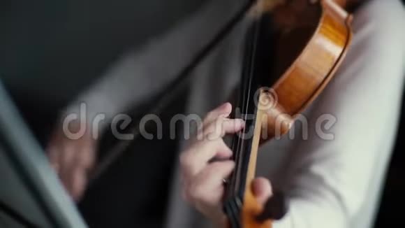 英俊的女人拉小提琴慢动作特写视频的预览图