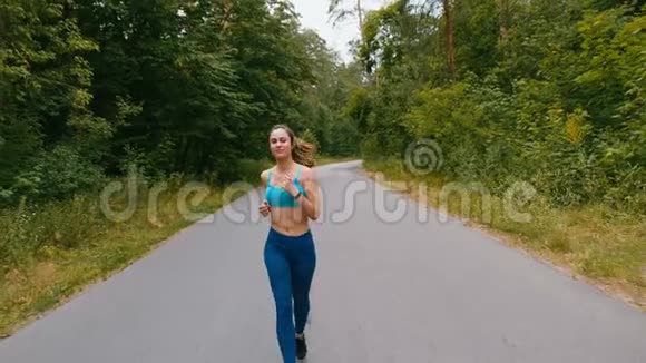 把女人关起来迷人的年轻女子在夏季森林或公园跑步女孩在户外慢跑卡迪奥视频的预览图