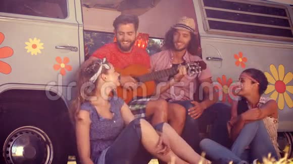 高质量的时尚朋友坐在露营车旁视频的预览图