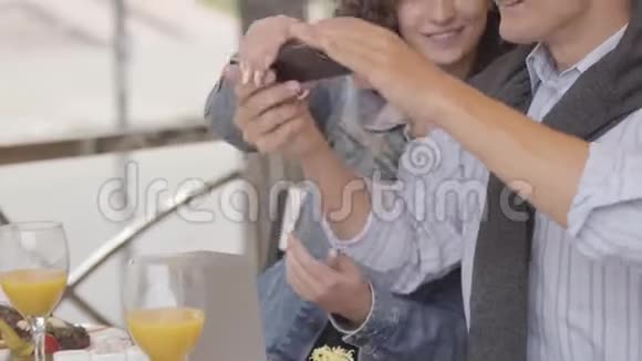 年轻人和女人在餐馆用手机拍照他们的食物这对幸福的夫妇享受着他们的生活视频的预览图