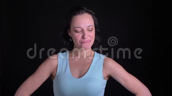 中年女性健美运动员的肖像展示她的二头肌在黑色背景下进入相机视频的预览图