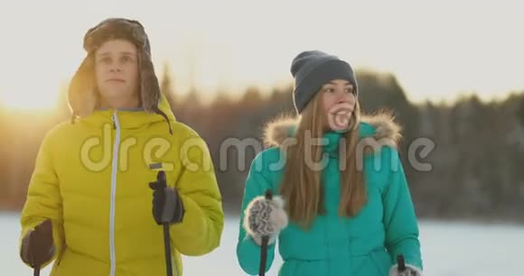 一个男人拥抱一个女人站在森林日落后一个冬天步行滑雪情人节浪漫和视频的预览图