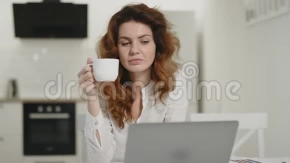 快乐的女人在偏远的工作场所工作笔记本电脑小姐在家喝茶视频的预览图