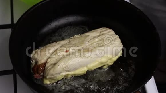 在一个加了黄油的加热煎锅里鸡角卷被炸了你可以看到油是如何沸腾的视频的预览图
