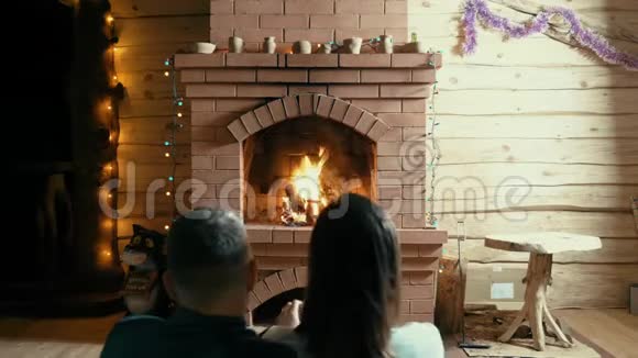 夫妻和狗坐在壁炉旁视频的预览图
