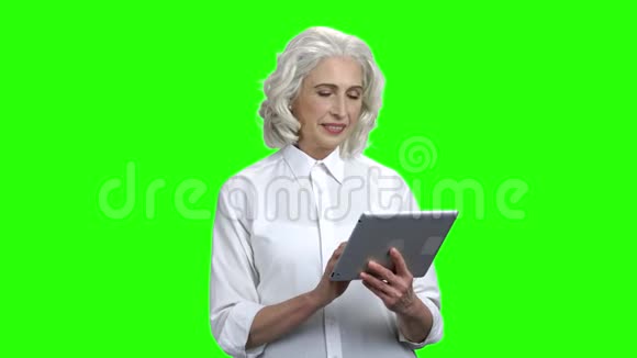 优雅的高级女性手持数字平板电脑视频的预览图