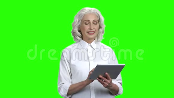 有吸引力的高级女士使用平板电脑视频的预览图