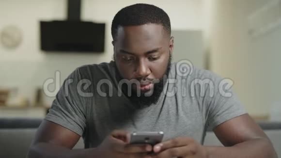 专心致志的人坐在电话里黑人打字信息的肖像视频的预览图