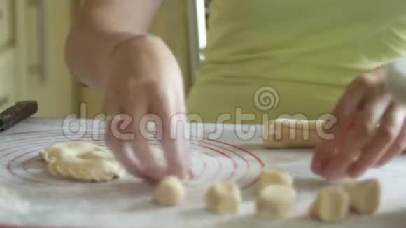 女人正在用一把刀切面团用小奶酪包饺子4K特写视频的预览图