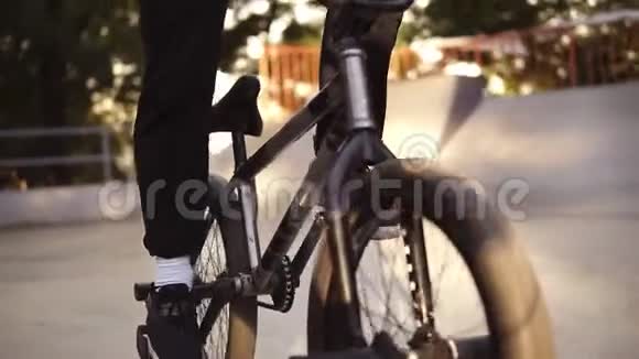 无法辨认的极端bmx自行车骑在他的黑色自行车在一个阳光明媚的溜冰公园夏天酷年轻的宝马自行车视频的预览图