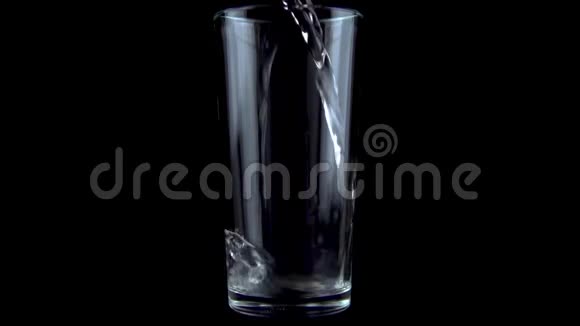 水倒入透明玻璃中黑色背景上的玻璃慢动作视频的预览图