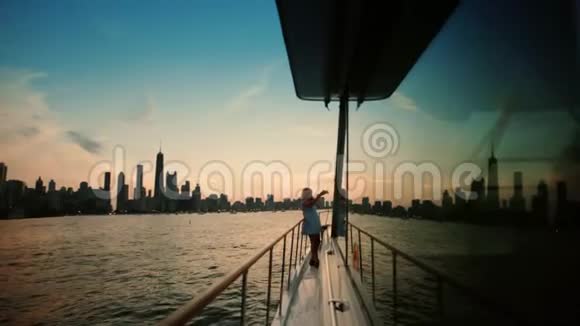 在游艇上旅行女人在美丽的夜晚城市的智能手机上拍照宽镜头视频的预览图