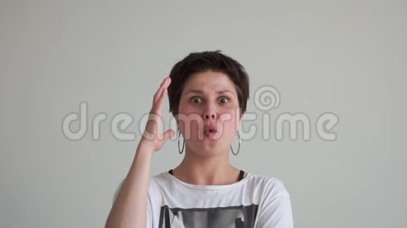 快乐的女孩戴着大耳环坐着惊讶地举起双手在斯洛文尼亚的一个工作室里视频的预览图