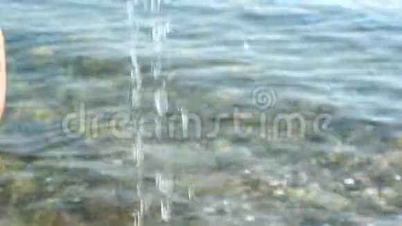 旅行概念小旅行者玩水海景背景下的水滴宝贝的手在玩视频的预览图