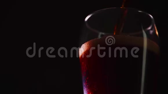 浇筑柯拉慢动作特写杯子里有气泡的可乐可乐汽水在黑色背景下特写慢动作视频的预览图