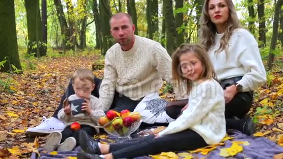 友好的家庭在秋天的森林里野餐视频的预览图