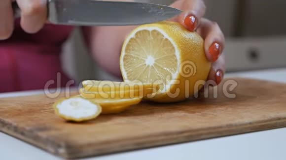 在木切割板上切柠檬女人切柠檬片视频的预览图