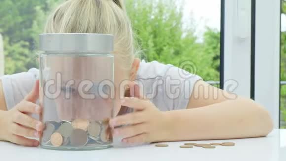 女孩把硬币放进罐子里视频的预览图
