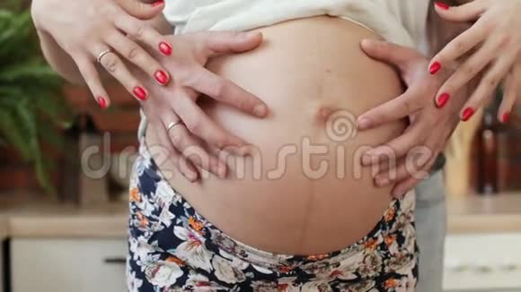 父母双手抚摸怀孕的腹部视频的预览图