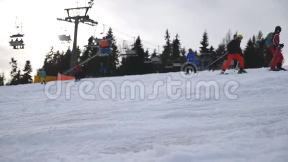 滑雪者滑下雪丘在滑雪场学习骑马人们从山上的雪坡上下来寒冷视频的预览图