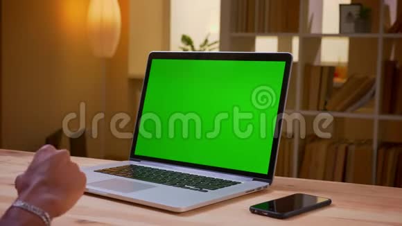 印度年轻商人在办公室室内使用带有绿色屏幕的笔记本电脑的特写后景拍摄没有脸视频的预览图