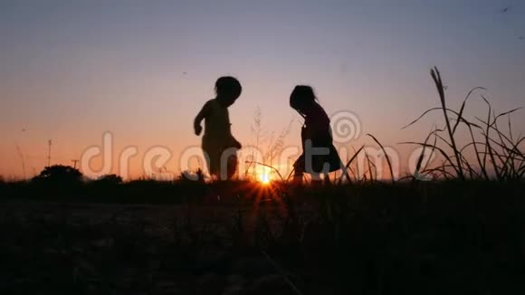 两个小女孩在夕阳背景下拥抱在一起的剪影视频的预览图