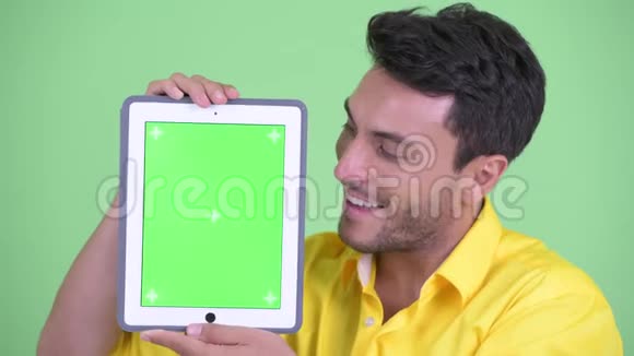 年轻的西班牙裔快乐商人展示数码平板电脑的脸视频的预览图