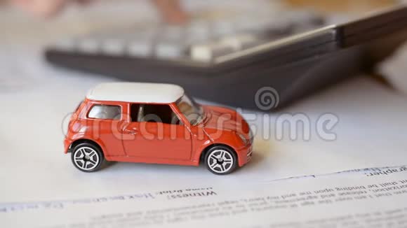 汽车保险概念红色汽车玩具和保险合同计算器视频的预览图