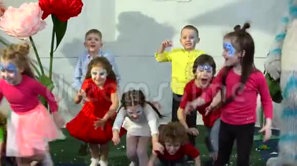 在娱乐中心学童在彩虹布下奔跑的慢动作视频的预览图