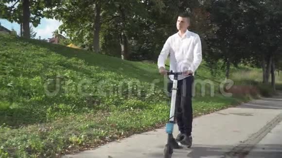 青年休闲商务学生骑电动滑板车在人行道上视频的预览图