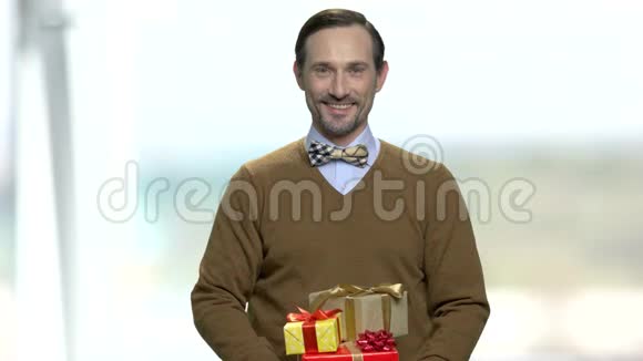 微笑的男人带着领结拿着礼品盒视频的预览图