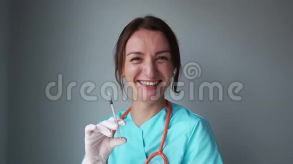 微笑的护士手里拿着注射器笑着用她的手做一个诱人的手势幽默精神病学的概念视频的预览图