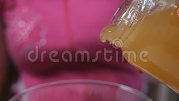 宝贝背景一股蜂蜜流入一个玻璃罐子特写镜头视频的预览图