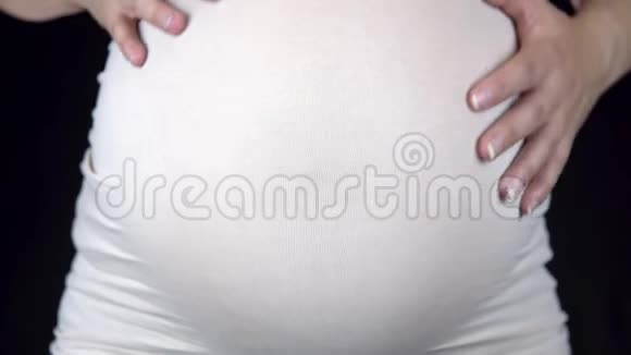 孕妇用手抚摸她的大肚子穿着轻便T恤的女人视频的预览图