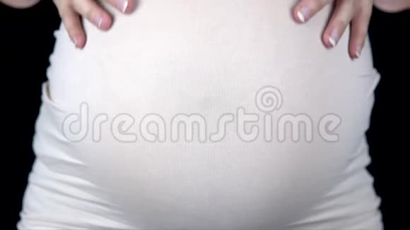 孕妇抚摸着她的胃从手中露出一颗心穿着轻便T恤的女人视频的预览图