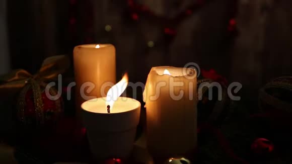 圣诞节的温暖三支点燃的蜡烛一支在前景中有着巨大的火焰红色和金色的球脱钩的球缎子视频的预览图