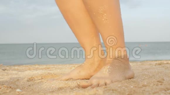 海水冲刷着晒黑的雌性脚美丽的年轻女子在暑假期间在海岸放松女孩的腿躺在上面视频的预览图
