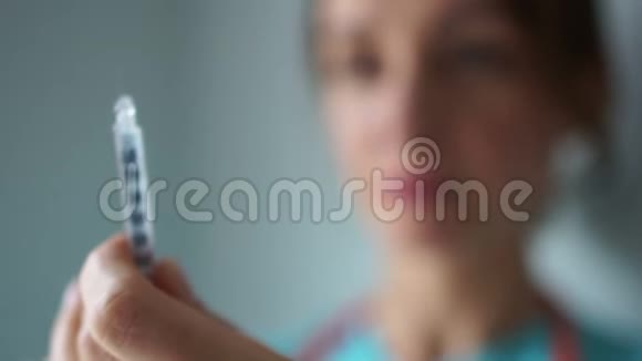 一名女医生的特写镜头她脸前拿着注射器糖尿病治疗流感疫苗视频的预览图
