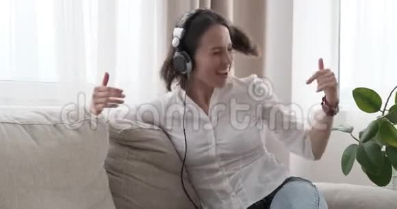 在家里听耳机音乐的女人很开心视频的预览图